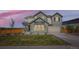 Beautiful two-story home with manicured lawn and modern architectural details at dusk at 6255 Kenzie Cir, Castle Pines, CO 80108