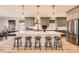 Modern kitchen with island seating, granite countertops, stainless appliances, and hardwood floors at 6255 Kenzie Cir, Castle Pines, CO 80108