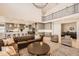 Open-concept living room featuring a leather sofa, modern decor, and a view of the kitchen at 6255 Kenzie Cir, Castle Pines, CO 80108