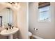 Elegant powder room featuring a pedestal sink, round mirror, and neutral tones at 6255 Kenzie Cir, Castle Pines, CO 80108