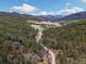 Breathtaking aerial view of property nestled within lush forest landscape in a serene, mountain setting at 7559 S Turkey Creek Rd, Morrison, CO 80465