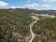 Scenic aerial view of the property surrounded by lush forest and rolling hills, providing privacy and tranquility at 7559 S Turkey Creek Rd, Morrison, CO 80465
