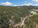 Picturesque aerial view showcasing the home's secluded location within a dense forest, offering serene mountain living at 7559 S Turkey Creek Rd, Morrison, CO 80465