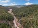 Breathtaking aerial shot showcases the property nestled amidst lush greenery, providing a tranquil and secluded mountain getaway at 7559 S Turkey Creek Rd, Morrison, CO 80465