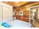 A cozy bedroom with wood paneled walls, closet, and neutral bedding offers a warm and inviting retreat at 7559 S Turkey Creek Rd, Morrison, CO 80465
