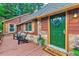 Charming front exterior featuring stone accents, wooden deck, and vibrant green front door with welcome mat at 7559 S Turkey Creek Rd, Morrison, CO 80465