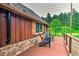Outdoor deck includes stone accents, wood railing, seating area, and mature trees at 7559 S Turkey Creek Rd, Morrison, CO 80465
