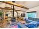 Spacious living room featuring rustic wood floors, stone accent wall, wood burning stove, and comfortable seating at 7559 S Turkey Creek Rd, Morrison, CO 80465