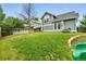 Grassy backyard, green house exterior, privacy fence, and patio space at 1280 W 134Th Pl, Westminster, CO 80234
