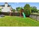 Fenced backyard features a well-maintained lawn and a wooden playset with swings and a slide at 1280 W 134Th Pl, Westminster, CO 80234