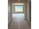 View of the foyer leading into a spacious room with large windows, offering plenty of natural light at 1713 Jennifer St, Brighton, CO 80601