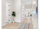 Bright hallway with wood floors, leading to a living room, featuring a decorative plant and modern rug at 5970 S Platte Canyon Dr, Littleton, CO 80123