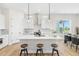 Beautiful kitchen featuring white cabinets, stainless appliances, a kitchen island and adjacent dining area at 5970 S Platte Canyon Dr, Littleton, CO 80123