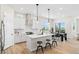 Bright, open kitchen with white cabinets, stainless steel appliances, and an island with bar seating at 5970 S Platte Canyon Dr, Littleton, CO 80123
