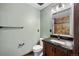 Bathroom featuring a granite countertop vanity with wood cabinetry and a tiled shower at 12570 W 60Th Ave, Arvada, CO 80004