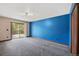 Bedroom featuring a sliding glass door to a deck and a vibrant blue accent wall at 12570 W 60Th Ave, Arvada, CO 80004