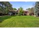 Back exterior view of a large brick home with a lush green yard at 12570 W 60Th Ave, Arvada, CO 80004