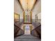 Stunning foyer with stone pillars, wooden beams, iron railing, and soaring chandelier at 12570 W 60Th Ave, Arvada, CO 80004