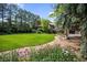 Charming brick home featuring a lush lawn, mature trees, and colorful flower beds at 12570 W 60Th Ave, Arvada, CO 80004