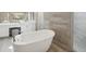 Elegant bathroom with a standalone tub, tiled walls, and dual vanity with bright lighting at 8803 Antero Ct, Arvada, CO 80007