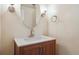 Bright bathroom featuring a wood vanity, white countertop, oval mirror, and modern fixtures at 300 Hudson St # 109, Denver, CO 80220