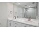 A well-lit bathroom features double sinks, vanity, and a large mirror that reflects the walk-in shower at 300 Hudson St # 109, Denver, CO 80220