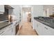Modern kitchen with stainless steel appliances, sleek white cabinetry, and hardwood floors at 300 Hudson St # 109, Denver, CO 80220
