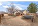 Backyard featuring mature trees, a trampoline and fence, complemented by a charming home at 12119 Forest St, Thornton, CO 80241