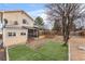 A home's backyard featuring both a covered porch, a wood deck, some grass, and some barren land at 12119 Forest St, Thornton, CO 80241