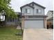 Charming gray two-story home with a basketball hoop and attached two car garage, and landscaped front yard at 12119 Forest St, Thornton, CO 80241