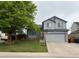 Charming gray two-story home with a basketball hoop, lush tree and well-manicured lawn at 12119 Forest St, Thornton, CO 80241