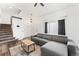 Comfortable living room with plush gray seating, light wood-look floors, and access to the stairway at 12119 Forest St, Thornton, CO 80241