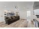 Open living room with recessed lighting, light wood-look flooring, gray couch and sliding doors to a playroom at 12119 Forest St, Thornton, CO 80241