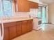 A well-lit kitchen with light brown cabinets, tile floor, stove, sink, and large glass doors at 451 Lansing St, Aurora, CO 80010