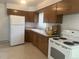 Bright kitchen with wood cabinets, tile floors, and white appliances with a large window at 451 Lansing St, Aurora, CO 80010