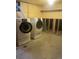 Laundry room with a modern front load washer and dryer set, shelf storage, and concrete floors at 451 Lansing St, Aurora, CO 80010
