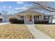 Ranch style home with front porch and landscaped lawn at 7447 Quay St, Arvada, CO 80003