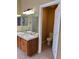 Bathroom with double sinks, wood cabinets, and a separate toilet room at 20148 E Dartmouth Dr, Aurora, CO 80013