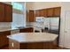 Well-appointed kitchen featuring an island, stainless steel refrigerator, and ample cabinet space at 20148 E Dartmouth Dr, Aurora, CO 80013