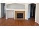 A cozy living room showcasing a tiled fireplace with built-in shelving and attractive hardwood flooring at 20148 E Dartmouth Dr, Aurora, CO 80013