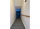 A well-lit stairway with gray stairs leads to a lower level at 20148 E Dartmouth Dr, Aurora, CO 80013