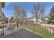 Spacious backyard with a wooden deck, well-maintained lawn, fenced perimeter, and mature trees and landscaping at 9724 Iris St, Broomfield, CO 80021