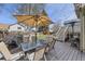 Outdoor patio featuring a glass-top table with chairs, an umbrella, a barbecue grill, and string lights at 9724 Iris St, Broomfield, CO 80021