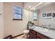 Inviting bathroom featuring a window, vanity with gray countertop, tile floor, and framed artwork on the walls at 9724 Iris St, Broomfield, CO 80021