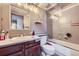 Well-lit bathroom featuring a shower and tub with tile surround, a vanity with wood cabinets and a mirror at 9724 Iris St, Broomfield, CO 80021