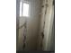 Modern bathroom with shower, glass door, vertical decorative stripe, and grab bar near a window at 3905 Nelson St, Wheat Ridge, CO 80033
