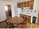 Eat-in kitchen has updated sink, wood cabinets, and access to living room at 3905 Nelson St, Wheat Ridge, CO 80033