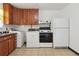 White appliances and wood cabinets in this functional kitchen at 7600 Monaco St, Commerce City, CO 80022