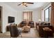 Spacious living room showcasing leather seating, neutral rug, and large window providing natural light at 7600 Monaco St, Commerce City, CO 80022