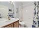 Bright bathroom with a shower-tub combo, white tile, and a wood vanity for a clean and functional space at 2265 S Depew St, Denver, CO 80227